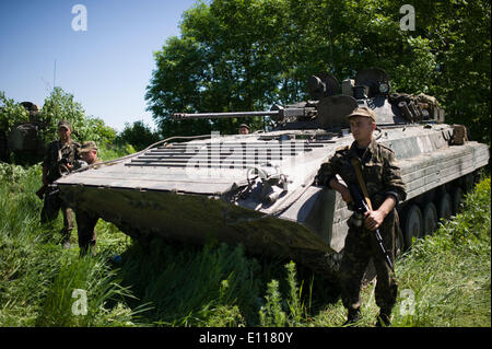 Donezk, Ukraine. 21. Mai 2014. Ein Soldat steht Wache neben einer bewaffneten Fahrzeug an einem Kontrollpunkt in der Nähe von Donetsk, Ukraine, 21. Mai 2014. Etwa 800 Soldaten der Ukraine haben mehrere Kontrollpunkte um Donezk eingerichtet, um die Straße von Donezk an der Grenze zu Russland am Mittwoch zu sichern. Das ukrainische Außenministerium am Mittwoch forderte Russland seine Bemühungen, die Krise in der Ostukraine verstärken. Bildnachweis: Dai Tianfang/Xinhua/Alamy Live-Nachrichten Stockfoto