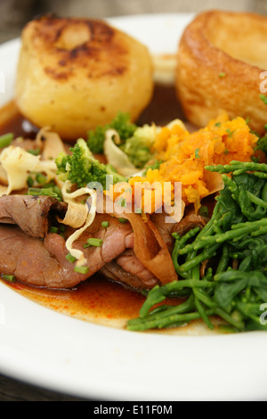 Gebratenes Rindfleisch Abendessen mit Bratkartoffeln, Yorkshire Pudding und Gemüse püriert Schwede und Queller Stockfoto