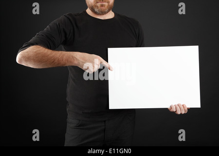 Mann in schwarzer Kleidung hält Plakat Stockfoto