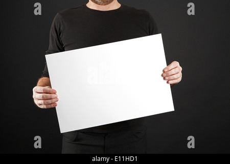 Mann in schwarzer Kleidung hält Plakat Stockfoto