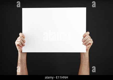 Mann in schwarzer Kleidung hält Plakat Stockfoto