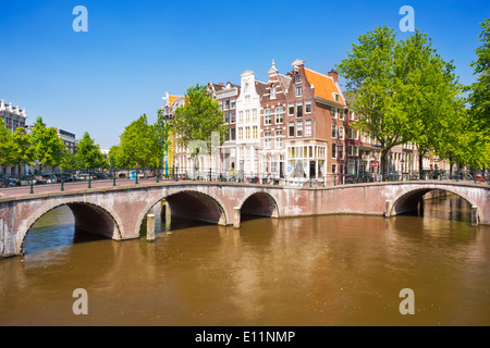 Brücken und Häuser an einem Kanal in der Stadt Amsterdam in den Niederlanden an einem schönen sonnigen Tag Stockfoto