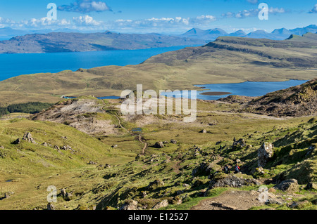 WANDERER AUF DEM FUßWEG NACH UNTEN AUS DER OLD MAN OF STORR AUF DER ISLE OF SKYE MIT BLICK AUF DIE INSEL RAASAY Stockfoto