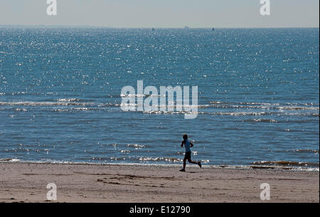 Swansea, Großbritannien. 21. Mai 2014.  Ein einsamer Jogger macht das Beste aus dem warmen Wetter am Strand von Swansea Bay heute als das Meer schimmert in der Sonne. Bildnachweis: Phil Rees/Alamy Live-Nachrichten Stockfoto