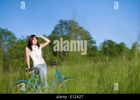 5. Juni 2010 - 5. Juni 2010 - Frau mit altmodischen Fahrrad im Sommerwiese an sonnigen Tag Stockfoto