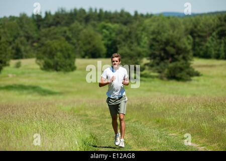 13. Juni 2009 - 13. Juni 2009 - junger Mann mit Kopfhörer Joggen auf einer Wiese, shallow DOF Ã'Â © CTK/ZUMAPR Stockfoto