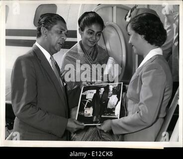 12. Dezember 2011 - internationaler Flughafen N.Y, Sept. 26 - Ceylon Minister für Finanzen, Stanley De Zoysa und seine Tochter, Frau Roma Jinadasa, beide angekommen erst gestern Morgen von Colombo, präsentieren sich mit einem Foto des verstorbenen Premierministers von Ceylon, s.w.r.d Bandaranaike (Taken bei seinem letzten Besuch in die Vereinigten Staaten im November 1956), TWA Gastgeberin Denis Luedtke vor dem Einsteigen in ein TWA Jetstream zurück nach Colombo. Herr De Zoysa wurde der Ermordung des Ministerpräsidenten bei der Ankunft gestern geraten und ist zur Teilnahme an der wilden Craiova am Mittwoch Bespannungsservice. Stockfoto