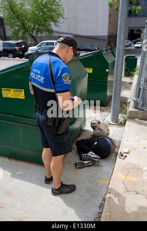 Polizist Fragen Obdachlosen Mann, der hinter geschlafen hatte Müllcontainer in der Innenstadt von Austin Texas Stockfoto