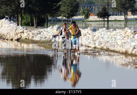 Sabac, Serbien. 21. Mai 2014. Bild aufgenommen am 21. Mai 2014 zeigt, dass zwei Bewohner versuchen zu vermeiden, einen Teich von Wasser mit ihren Bikes in der Stadt Šabac, etwa 90 Kilometer westlich von Belgrad, Serbien. Serbien bereit Abwehr gegen eine zunehmende des Sava Flusses aufgrund der heftigen Regenfälle, die Balkan geschlagen. Serbien ist seit Mai 15 unter Ausnahmezustand. Bildnachweis: Nemanja Cabric/Xinhua/Alamy Live-Nachrichten Stockfoto