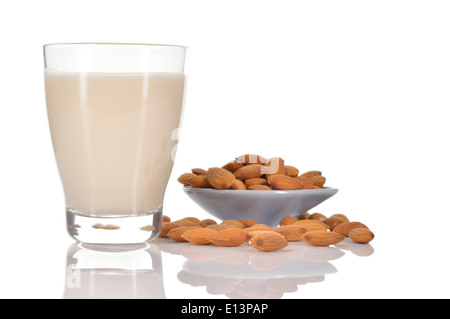 Mandel-Milch als Ersatz für Kuhmilch. Glas Mandelmilch und einige Mandeln auf eine Untertasse isoliert auf weißem Hintergrund. Stockfoto