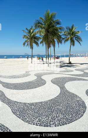 Kultige Bürgersteig Fliesen Muster mit Palmen am leeren Blick auf Copacabana Strand Rio de Janeiro Brasilien Stockfoto