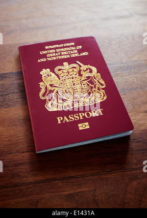 Ein alter EU-Stil vor dem Brexit burgunderrot UK Passport auf einem dunklen Holz Tischplatte Hintergrund. Stockfoto