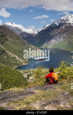 Norwegen, Geiranger, Geiranger Fjord. Blick auf Dorf und Kreuzfahrt-Schiff MS Rotterdam der Holland America Line. Wanderer Stockfoto