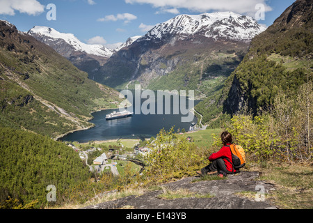 Norwegen, Geiranger, Geiranger Fjord. Blick auf Dorf und Kreuzfahrt-Schiff MS Rotterdam der Holland America Line. Wanderer Stockfoto