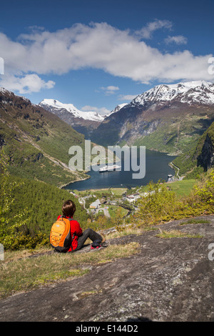 Norwegen, Geiranger, Geiranger Fjord. Blick auf Dorf und Kreuzfahrt-Schiff MS Rotterdam der Holland America Line. Wanderer Stockfoto