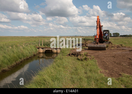 Verwenden einen Bagger für Wartungsarbeiten an der Schleuse in Deepdale Marsh North Norfolk. Stockfoto