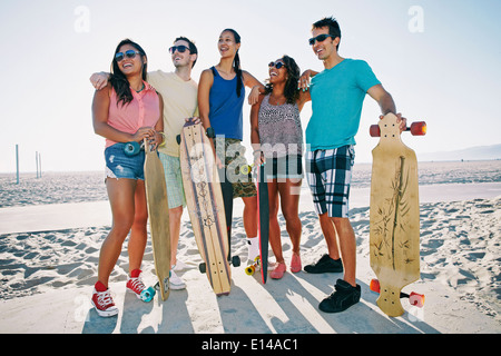 Freunde halten Longboards am Strand Stockfoto