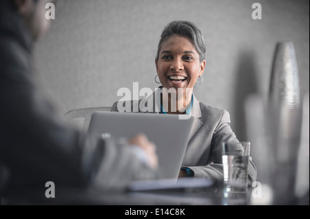 Geschäftsfrau, die lachend in treffen Stockfoto