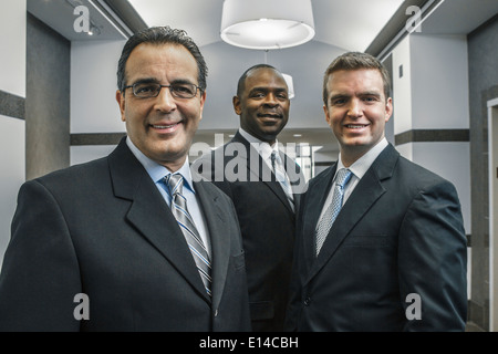 Geschäftsleute, die lächelnd im Büro Korridor Stockfoto