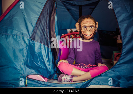 Gemischte Rassen Mädchen mit Maske im Zelt Stockfoto