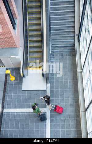 Unternehmerinnen im Gespräch in der Nähe von Treppen und Rolltreppen Stockfoto