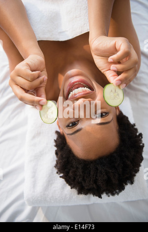 Porträt von lächelnden schwarze Frau mit Gurkenscheiben Stockfoto