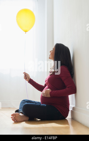 Schwanger Hispanic Frau Holding Ballon Stockfoto