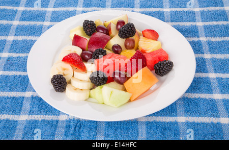 Ein Teller mit frischem ganze und geschnittene Obst wie Brombeeren, Melonen, Bananen und Äpfel Stockfoto