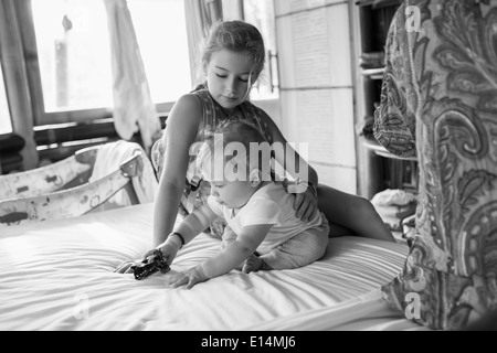 Kaukasische Mädchen und Baby Boy Spielen auf Bett Stockfoto