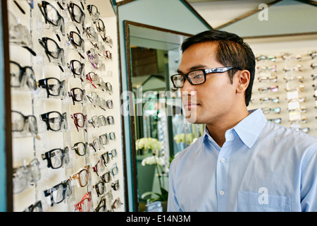 Philippinischen Mann versucht auf Gläser beim Optiker Stockfoto