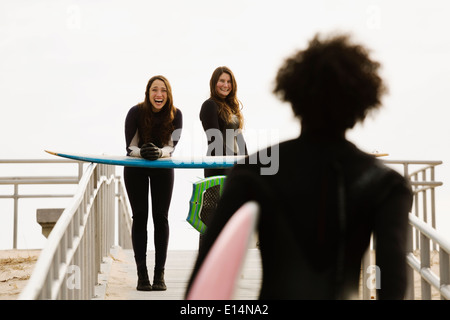 Surfer, die Bretter zum Strand tragen Stockfoto