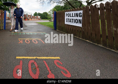 CHIPPENHAM, UK, 22. Mai 2014. Ein Mann und eine Frau verlassen ein Wahllokal in Chippenham, Wiltshire nach der Abstimmung bei der Europawahl 2014. Bildnachweis: Lynchpics/Alamy Live-Nachrichten Stockfoto