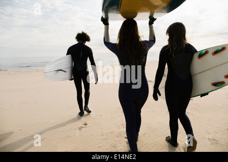 Surfer, die Bretter am Strand tragen