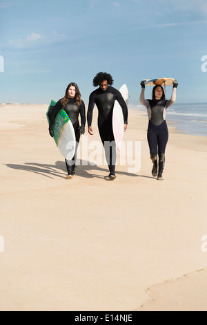 Surfer, die Bretter am Strand tragen Stockfoto