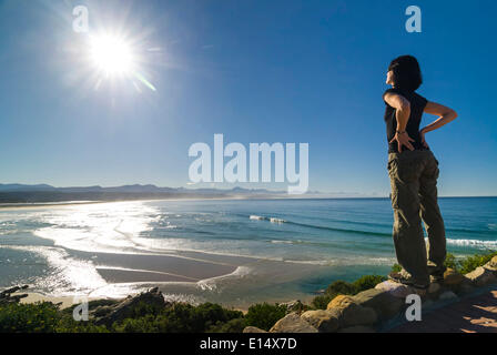 Junge Frau, Blick auf eine Bucht und den Indischen Ozean, Plettenberg Bay oder Plettenbergbaai, Garden Route, Eden District, Western Cape Stockfoto