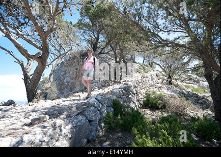 Eine 50 Jahre alte Frau geht auf den Erzherzog Weg am Grat des Es Caragoli in der Serra de Tramuntana-Gebirge auf Mallorca. Stockfoto