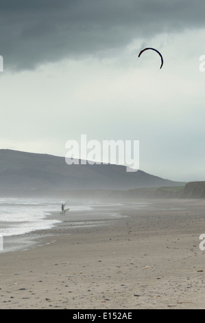 Eine einsamer Kitesurfer Spaziergänge am Strand, Wind, schwierige Bedingungen in der Hölle Mund Bay, North Wales zu genießen Stockfoto