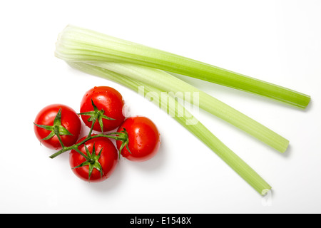 Draufsicht auf jede Menge frische Tomaten und Stangensellerie auf weißem Hintergrund Stockfoto