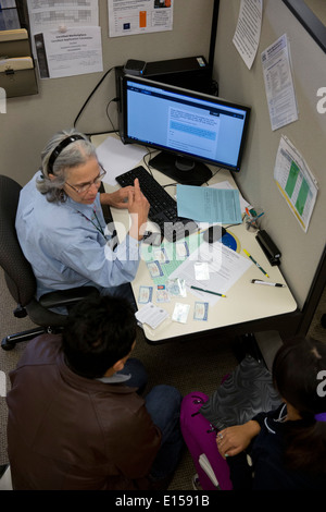 Gemeinschaft für lokale Non-Profit Gruppe freiwilliger anmeldet Client für die Krankenversicherung unter die bezahlbare Pflege Act in Austin TX Stockfoto