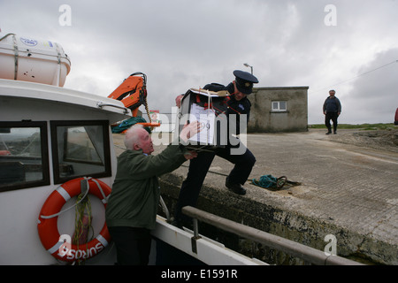 Vorsitzender Offizier Hugh O'Donnell und Garda Officer p.j. McHugh tragen die Wahlurne auf der Insel Innishfree, County Donegal, Stockfoto