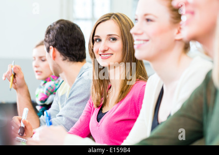 College-Studenten machen Unterrichtsnotizen in Universitätsaula Stockfoto