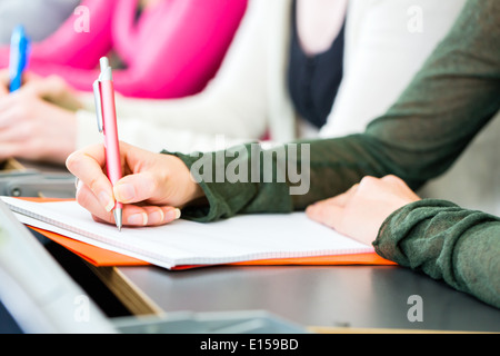 College-Studenten machen Unterrichtsnotizen in Universitätsaula Stockfoto