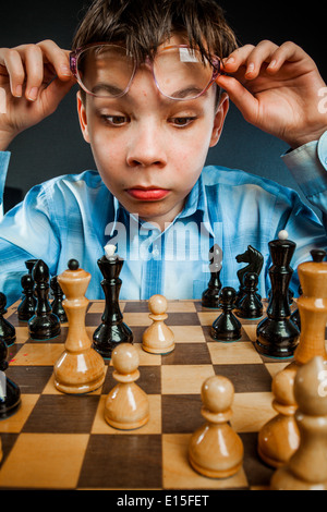 Wunderkind spielen Schach. Lustige Nerd Boy. Stockfoto