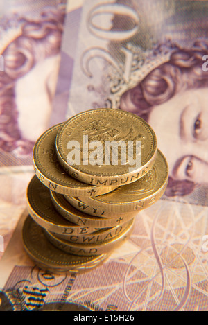 ein Haufen Pfund-Münzen und einige zwanzig Pfund-Noten Stockfoto