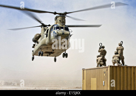 Eine Armee CH-47 Chinook Hubschrauber Last Team bereitet sich hook up einen Container zum 18. Juni 2013 in der Provinz Uruzgan, Afghanistan geflogen werden. Die Ausrüstung ist in Kandahar Flugplatz verschoben wird, wie FOB Hadrian heruntergefahren. Stockfoto