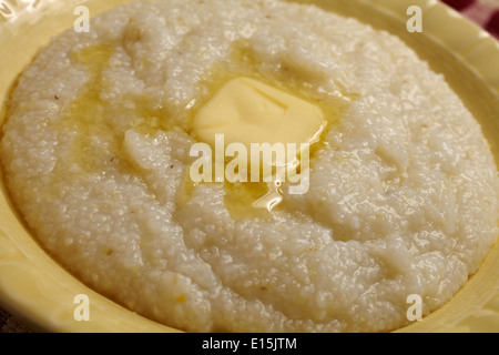 Schüssel mit Hominy Grits mit einem Klaps von butter Stockfoto