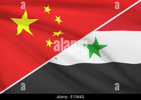 Flaggen von China und der Arabischen Republik Syrien im Wind wehen. Teil einer Serie. Stockfoto