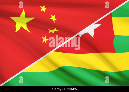 Flaggen von China und République Togolaise (Republik Togo) im Wind wehen. Teil einer Serie. Stockfoto