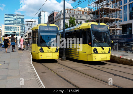 Zwei gelbe Metrolink Straßenbahnen am St Peters Square Station in Manchester City centre UK Stockfoto