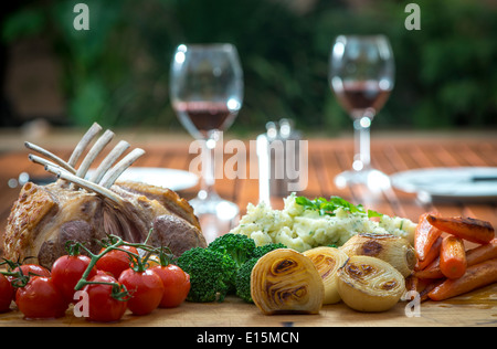 Gebratenes Lammkarree mit gebratenem Gemüse, Zwiebeln, Karotten, Tomaten, Brokkoli und Kartoffelpüree Stockfoto